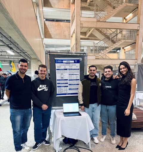 The Know How team next to the project poster at the FACENS project showcase